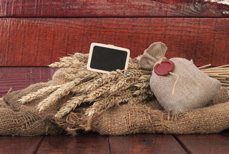 Ears Of Wheat And Sack Of Wheat Grains On Brown Wooden Background Stock