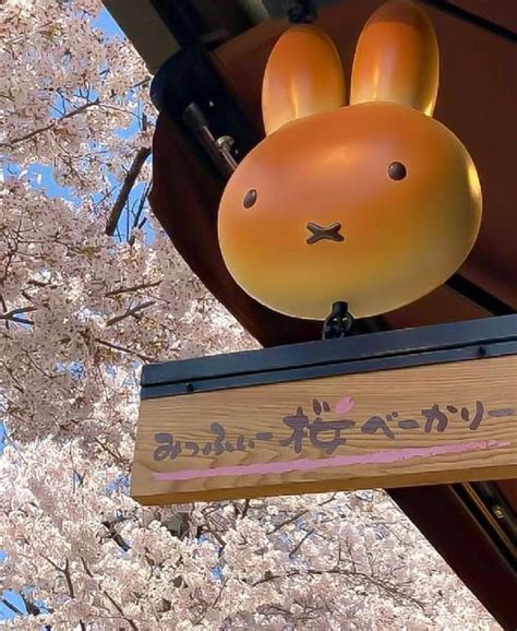 A Wooden Sign Hanging From The Side Of A Building Next To Cherry