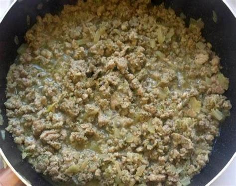 A Pan Filled With Food Sitting On Top Of A Stove