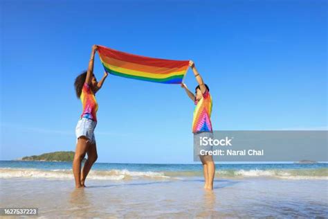 Women Lesbian Couple In Love On The Beach With A Rainbow Flag A Symbol