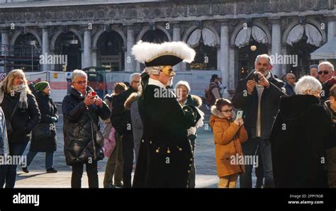 Man In Carnival Costume Poses For Tourists In San Marco Square In