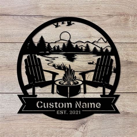 A Wooden Sign That Says Custom Name With Two Chairs And A Campfire In