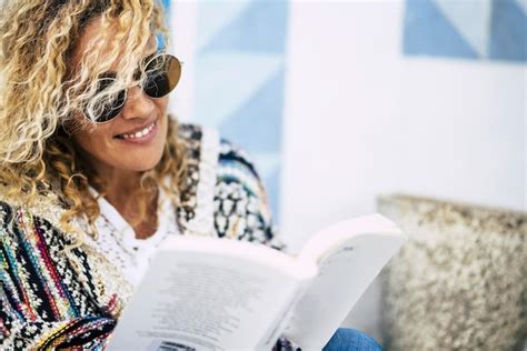 Premium Photo Woman Wearing Sunglasses Reading Book While Sitting