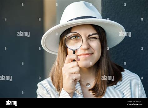 Curious Young Woman Looking Through A Magnifying Glass Stock Photo Alamy