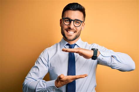 Young Handsome Businessman Wearing Tie And Glasses Standing Over Yellow