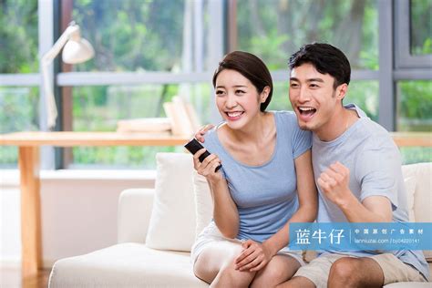 兴奋的年轻夫妇看电视 蓝牛仔影像 中国原创广告影像素材