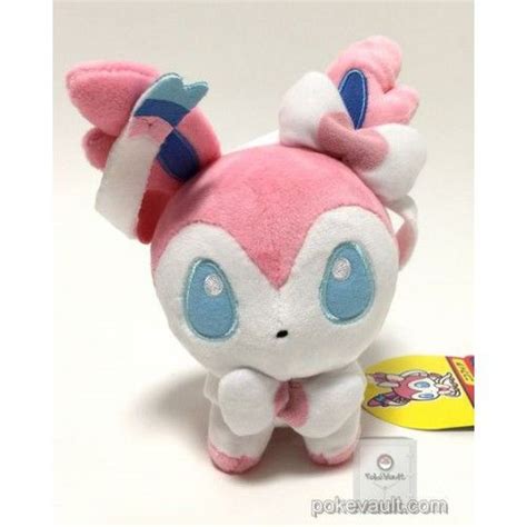 A Pink And White Stuffed Animal With Blue Eyes