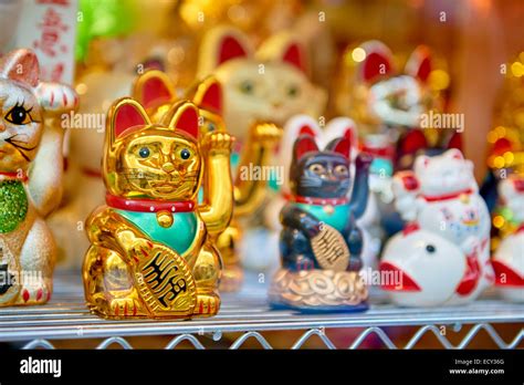 Several Traditional Japanese Waving Cats With A Golden One In Focus