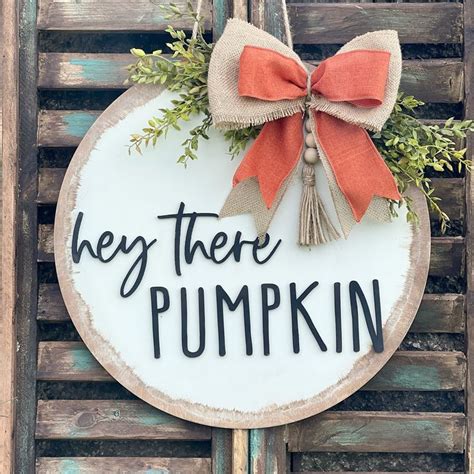 A Sign That Says Hey There Pumpkin Hanging On The Side Of A Wooden Door