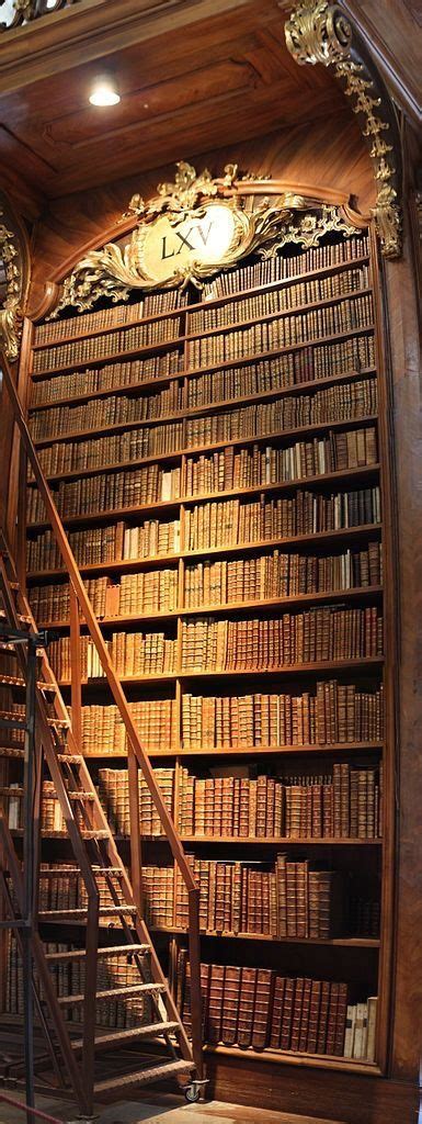 An Old Library With Many Books On The Shelves And Stairs Leading Up To