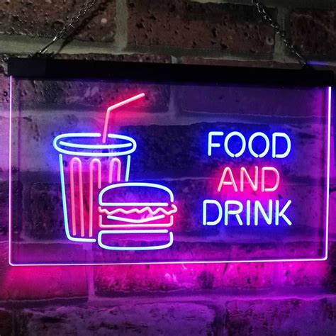 A Neon Sign That Says Food And Drink On The Side Of A Brick Wall