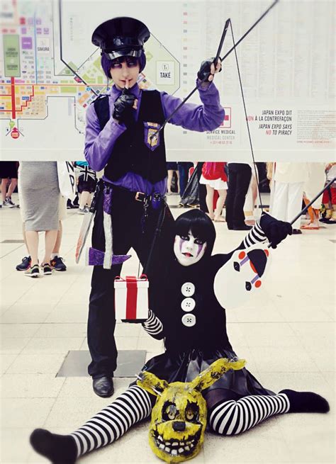 two people in costumes standing next to each other on the ground with ...