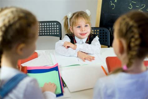 坐在桌上的三位年轻女小学生 库存照片 图片 包括有 生活方式 学员 学生 缩放比例 童年 逗人喜爱 83754988