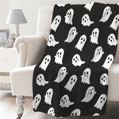 A Black And White Blanket With Ghost Faces On It Is Sitting In Front Of