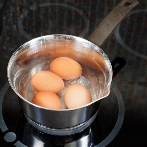 Ovos de galinha são cozidos em panela de metal Foto Premium