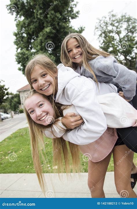 Group Of Teenage Girls Playing And Smiling Together Outdoors Stock