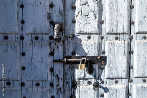 Front View Of The Knocker Of An Old Blue Painted Wooden Door With Rusty