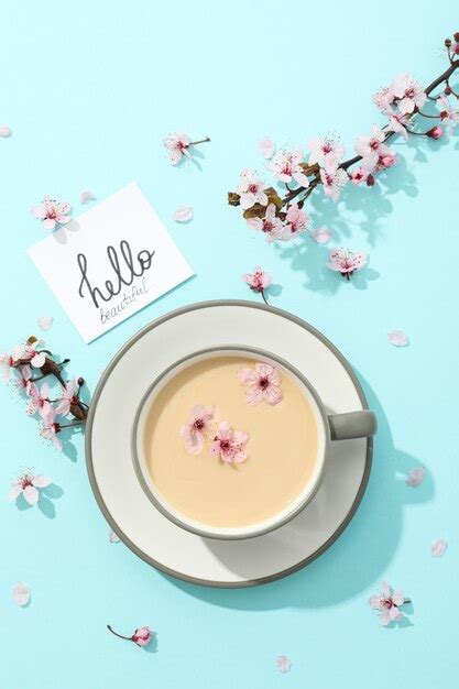 Premium Photo Spring Twigs With Flowers With A Cup Of Hot Drink On A Light Wooden Background