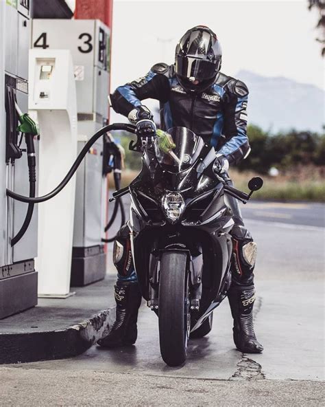 A Man On A Motorcycle At A Gas Station