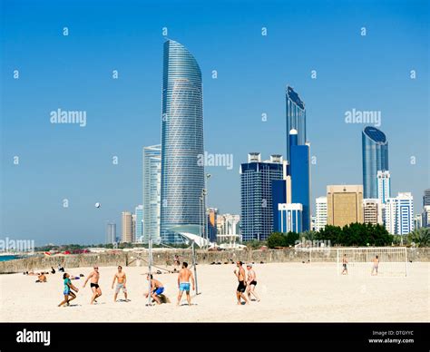 Volleyball game on Corniche beach with skyline in Abu Dhabi United Arab ...