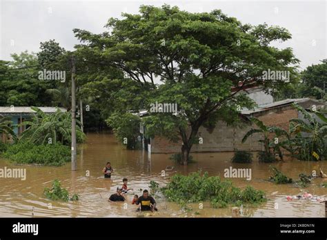 Residents Cross The Floods That Inundate Their Settlements To Flee To