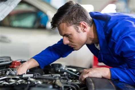 Mecánico De Servicio A Un Motor De Coche Foto Gratis