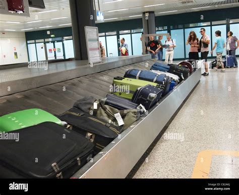 Waiting For Luggage And Suitcases At A Baggage Carousel Claim