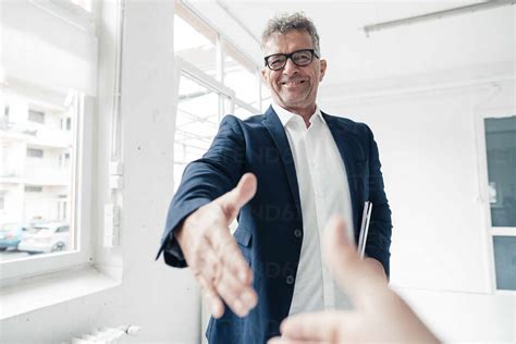 Happy Businessman Handshaking With Colleague In Office Stock Photo