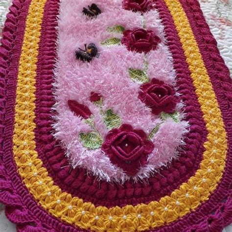 A Crocheted Rug With Flowers On It Sitting On Top Of A White Table