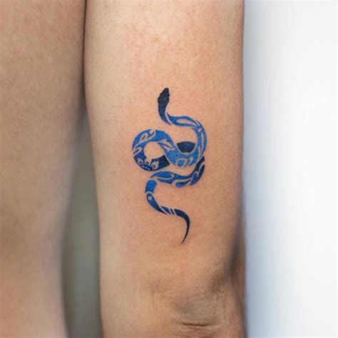 Blue porcelain snake tattoo placed on the tricep.