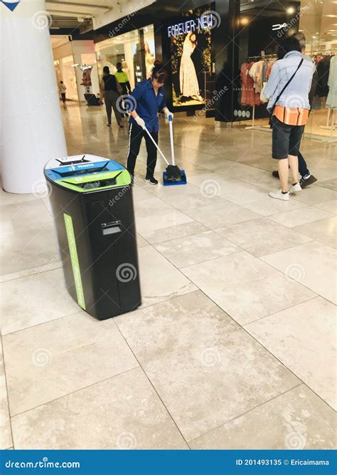 A Female Cleaner Sweeps the Floor in the Mall. Editorial Image - Image