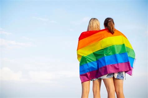 Premium Photo Lesbian Couple Holding Lgbt Flag And Hugging Outdoors