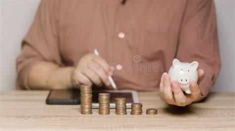 A Man Is Calculating Money To Save And Puts It In A Piggy Bank Ideas