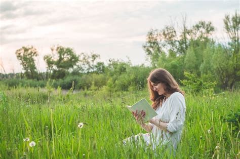 Premium Photo Beautiful Girl In Field Reading A Book The Girl