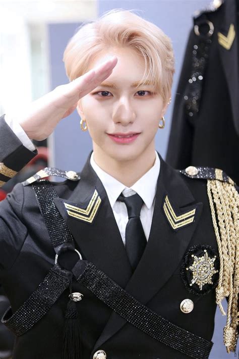 A Man In Uniform Saluting For The Camera With His Hand Up To His Head