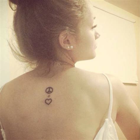 Upper back tattoo of a heart and the peace symbol.