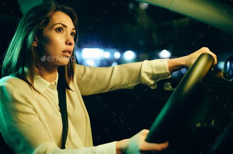 Young Sad Woman Crying While Driving Alone In A Car At Night Stock