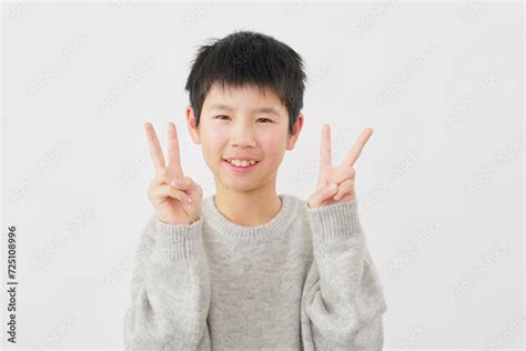 両手でピースサインをする男の子 白背景 Stock Foto Adobe Stock