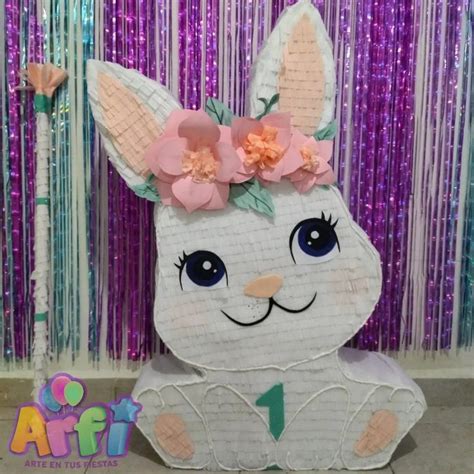 A Paper Bunny With Flowers On Its Head Sitting In Front Of A Purple