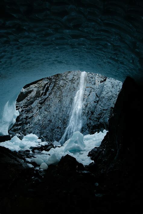 A large ice cave with a waterfall coming out of it photo – Free ...