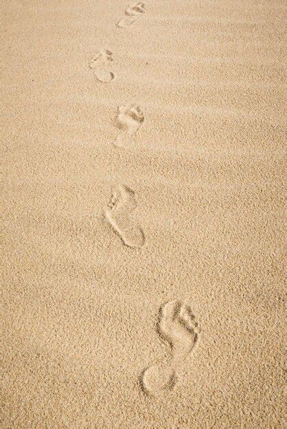 Huellas De Pies Descalzos En La Arena Caminando En La Playa Foto Premium