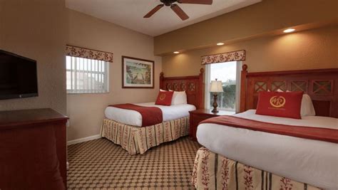 A Hotel Room With Two Beds And A Flat Screen Tv