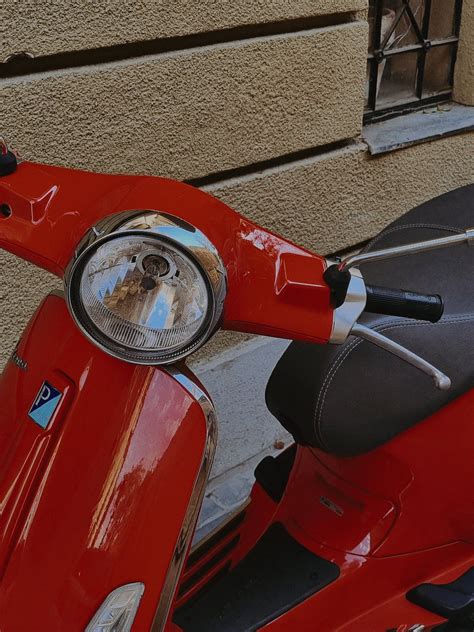 Red Vespa Motor Scooter Near Beige Wall · Free Stock Photo