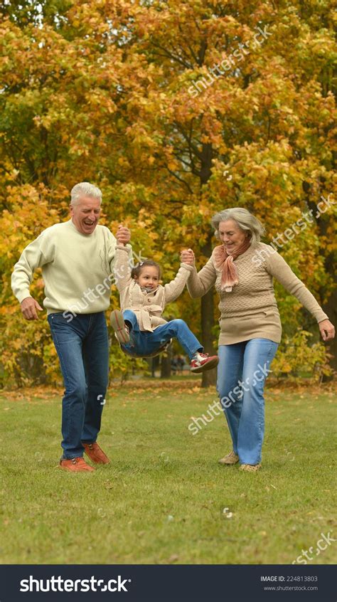 Grandparents And Grandchild Together In Autumn Park Sibling