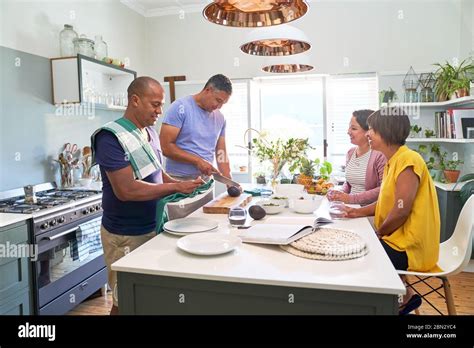 Mature Wives Watching Husbands Cook In Kitchen Stock Photo Alamy