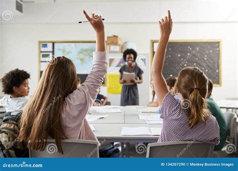 High School Students Raising Hands To Answer Question Set By Teacher In