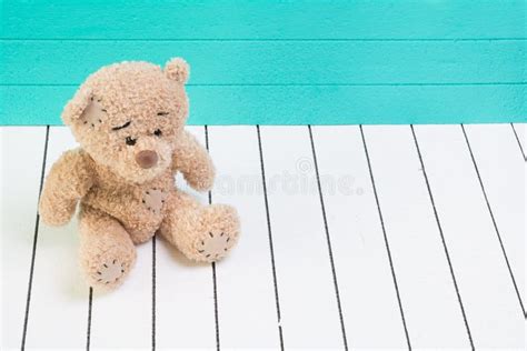 Ours De Nounours Se Reposant Sur Le Plancher En Bois Blanc Avec Le Fond