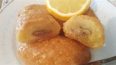 A White Plate Topped With Pastries And Lemon Wedges