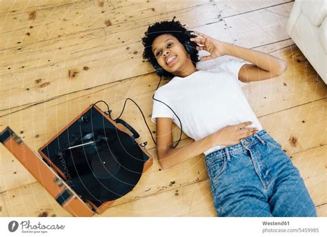 Young woman at home listening vinyl records, lying on ground - a Royalty Free Stock Photo from ...