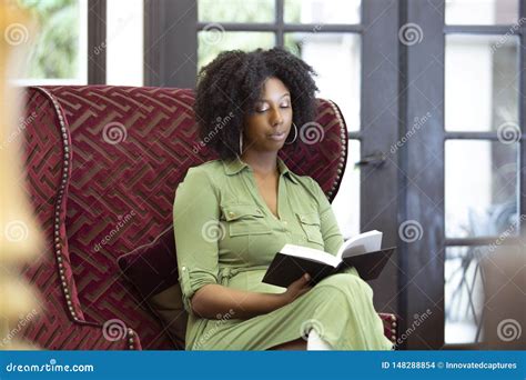 Black Female Reading A Book In A Living Room Stock Photo Image Of